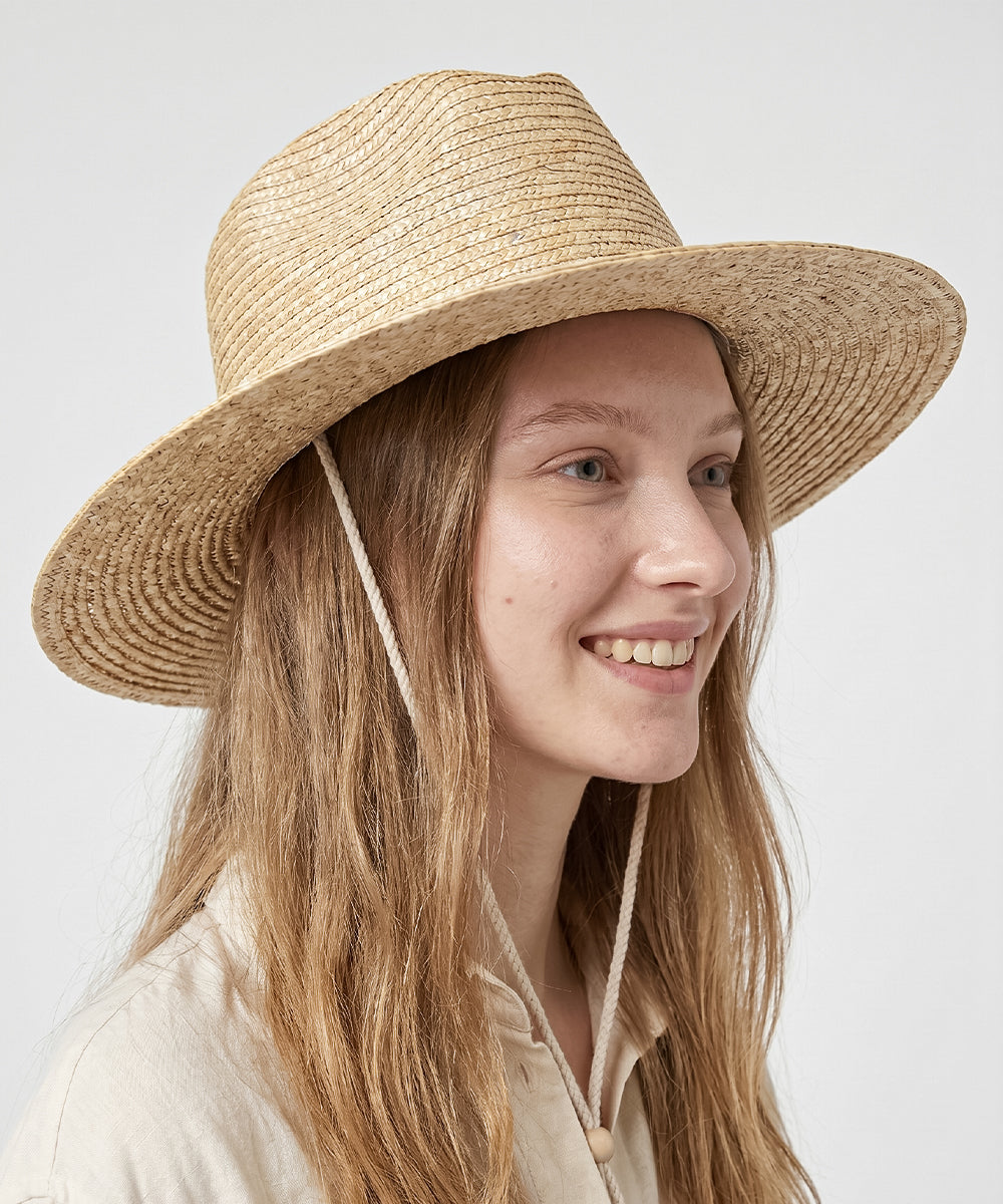 Quiet luxury poolside lookbook accessorized by a classic natural tan beach hat with chin strap