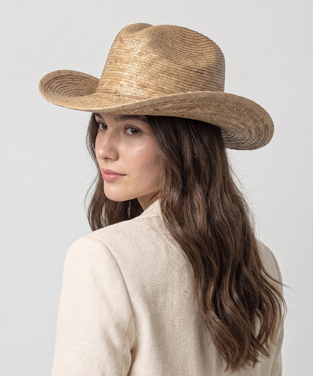 Premium boutique holiday wear capsule styled with a dark chestnut brown straw hat