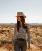 Female model styling the unisex Latitude natural felt cowboy hat for an outdoor road trip