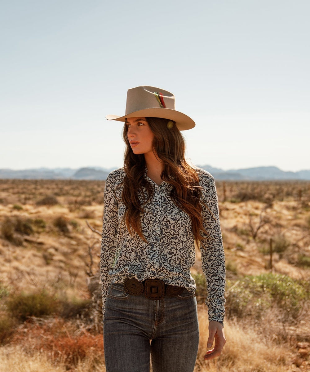 Female model styling the unisex Latitude natural felt cowboy hat for an outdoor road trip