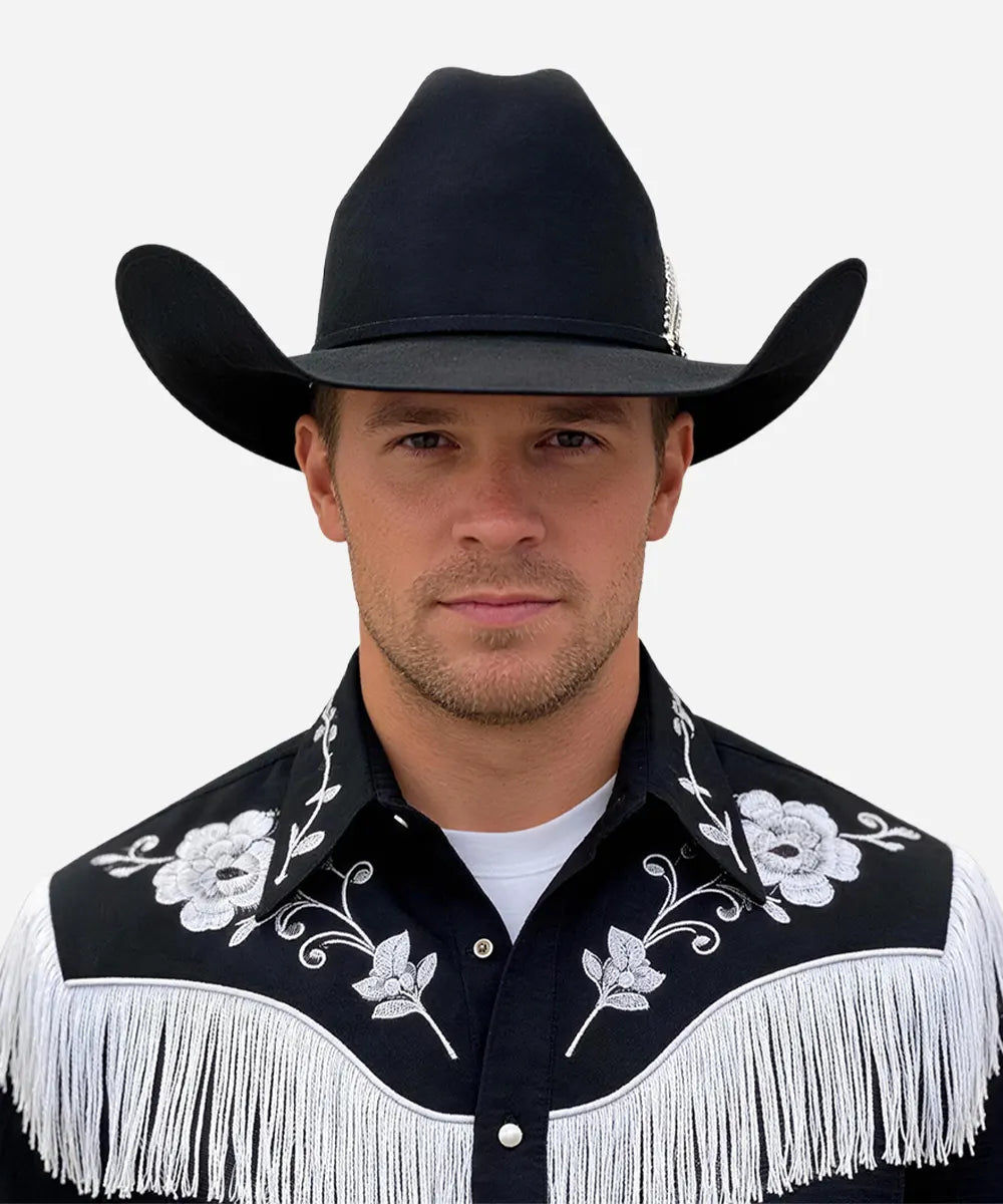 Male model in a traditional embroidered western shirt wearing the Magnate black fur felt hat while riding a horse