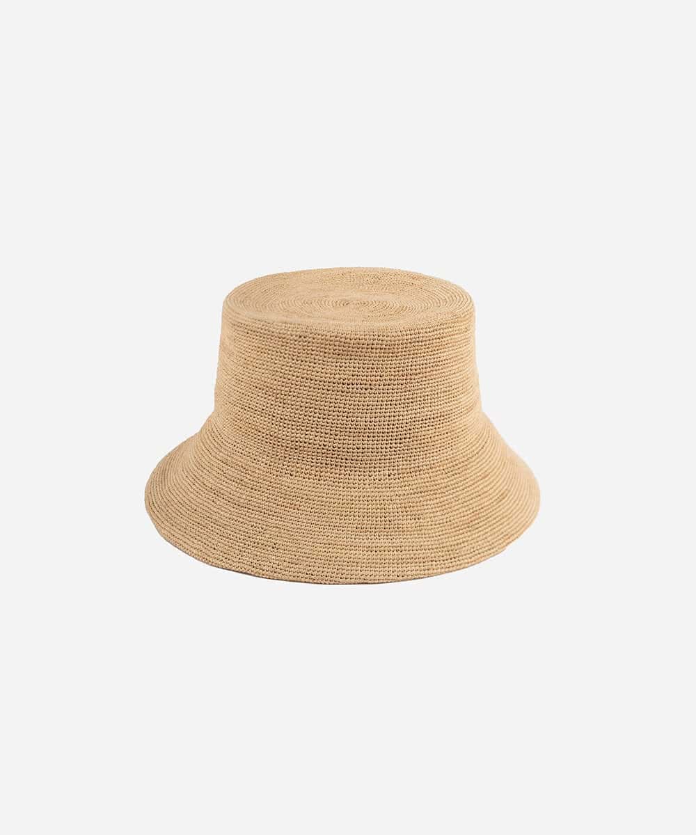 Flexible Solstice packable straw bucket hat in natural tone showing its lightweight and rollable construction LBORA