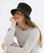 Studio presentation of the Solstice packable sun hat collection in classic black and natural straw variants